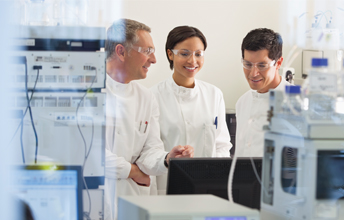Scientists in laboratory checking results on a computer