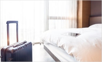 Hotel bed with luggage
