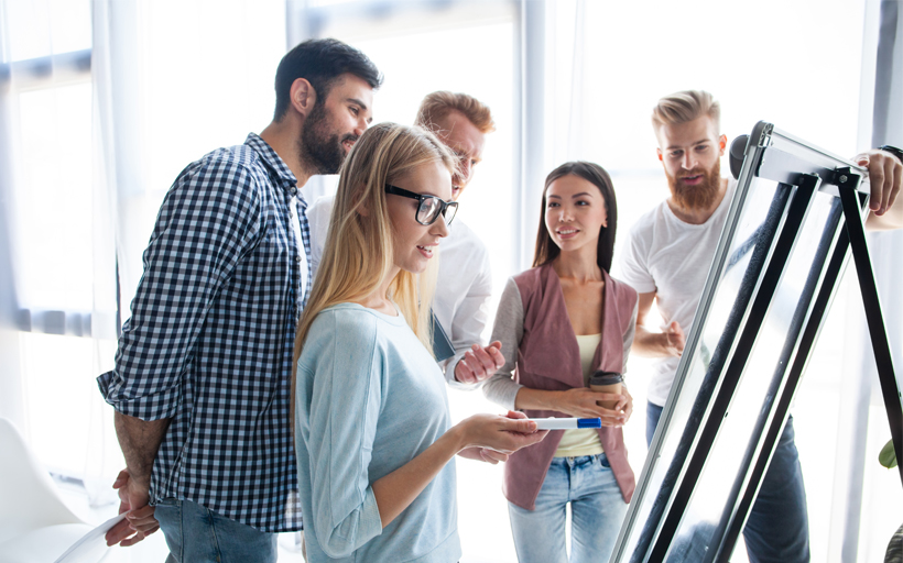 Compañeros de trabajo de pie juntos en la oficina moderna y de intercambio de ideas